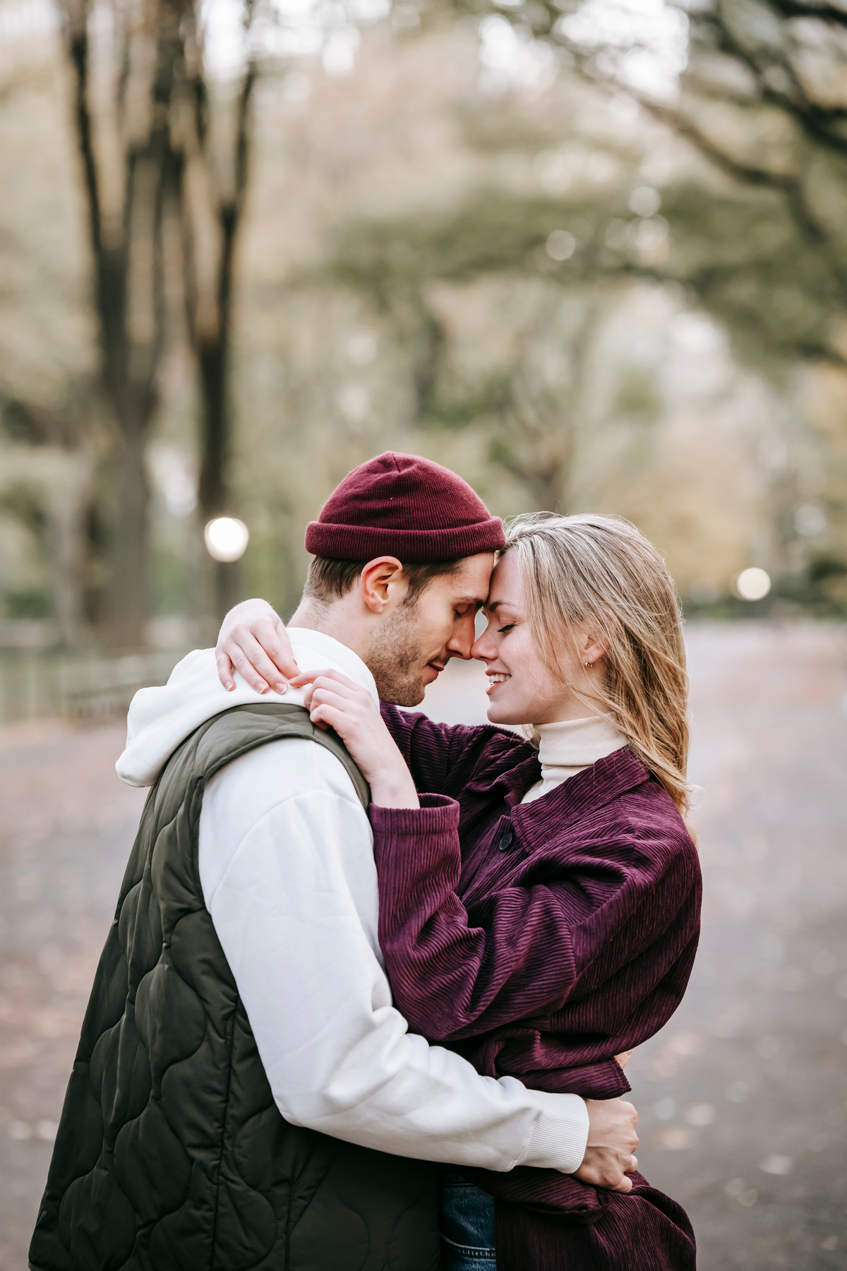 Smiling couple embracing on pathway in urban park